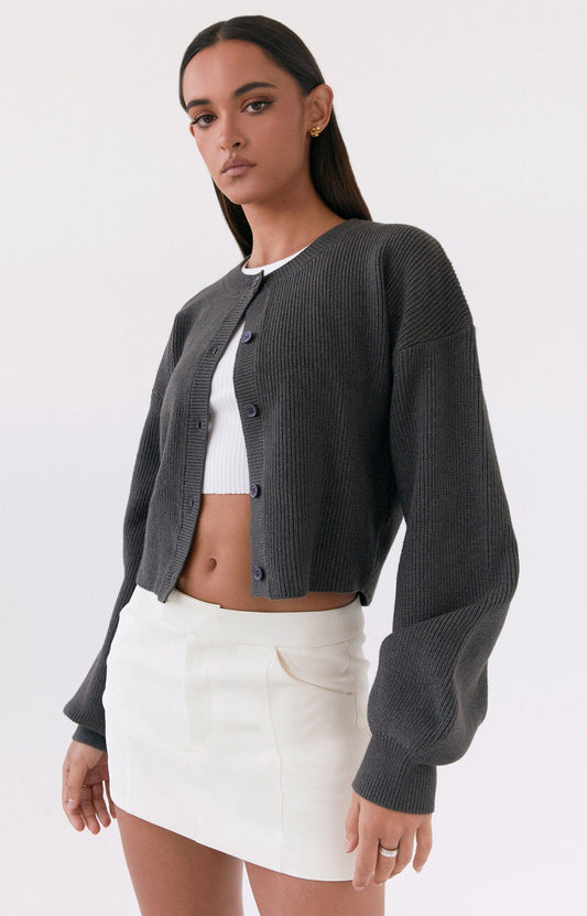 A woman wearing a dark grey sweater from Peppermayo US outerwear collection