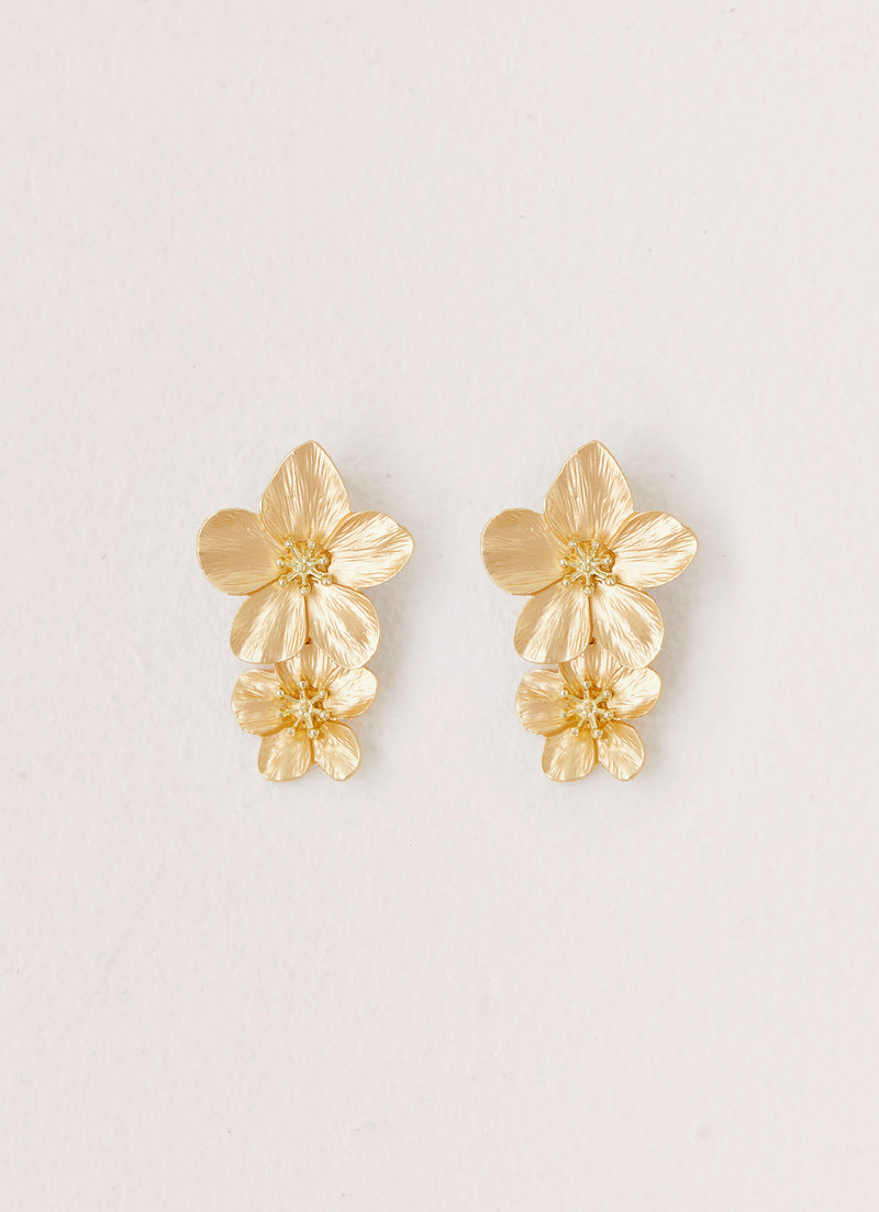 Womens Lola Love Flower Earrings in the colour Gold in front of a light grey background