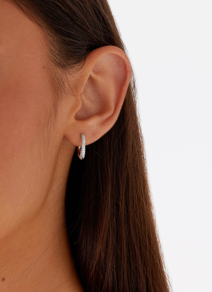 Womens Monica Huggie Earrings in the colour Silver in front of a light grey background