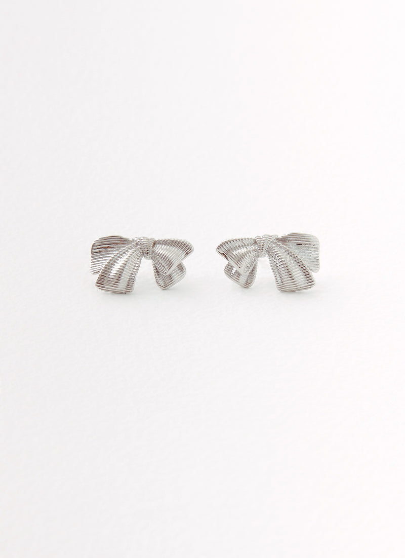 Womens Kiyah Bow Earrings in the colour Silver in front of a light grey background