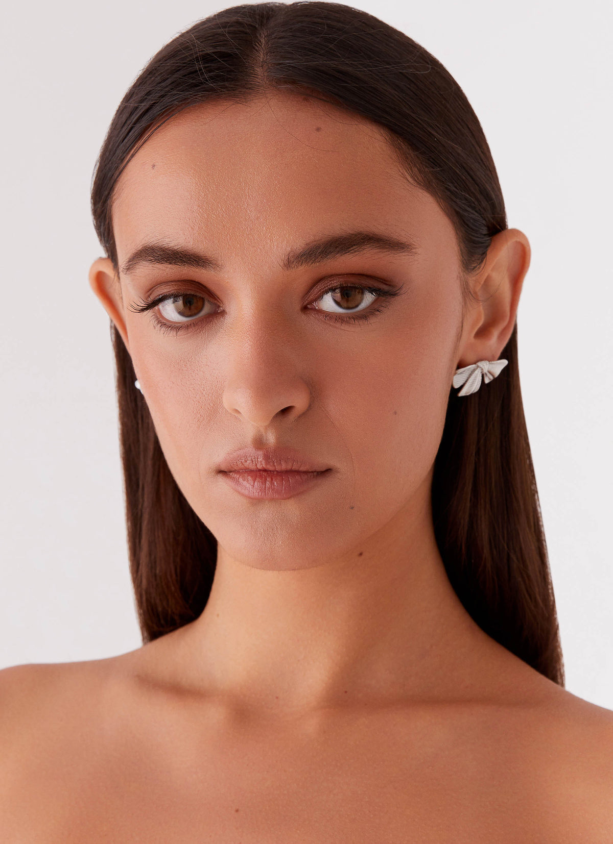 Womens Kiyah Bow Earrings in the colour Silver in front of a light grey background