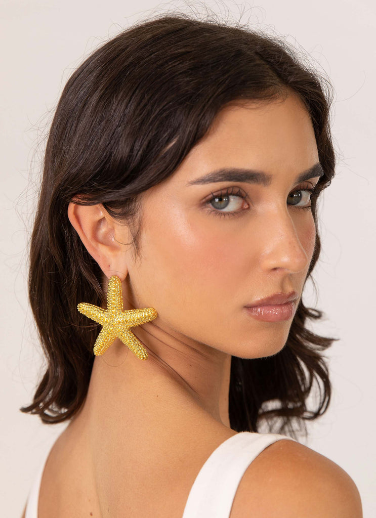 Womens Geneve Starfish Earring in the colour Gold in front of a light grey background